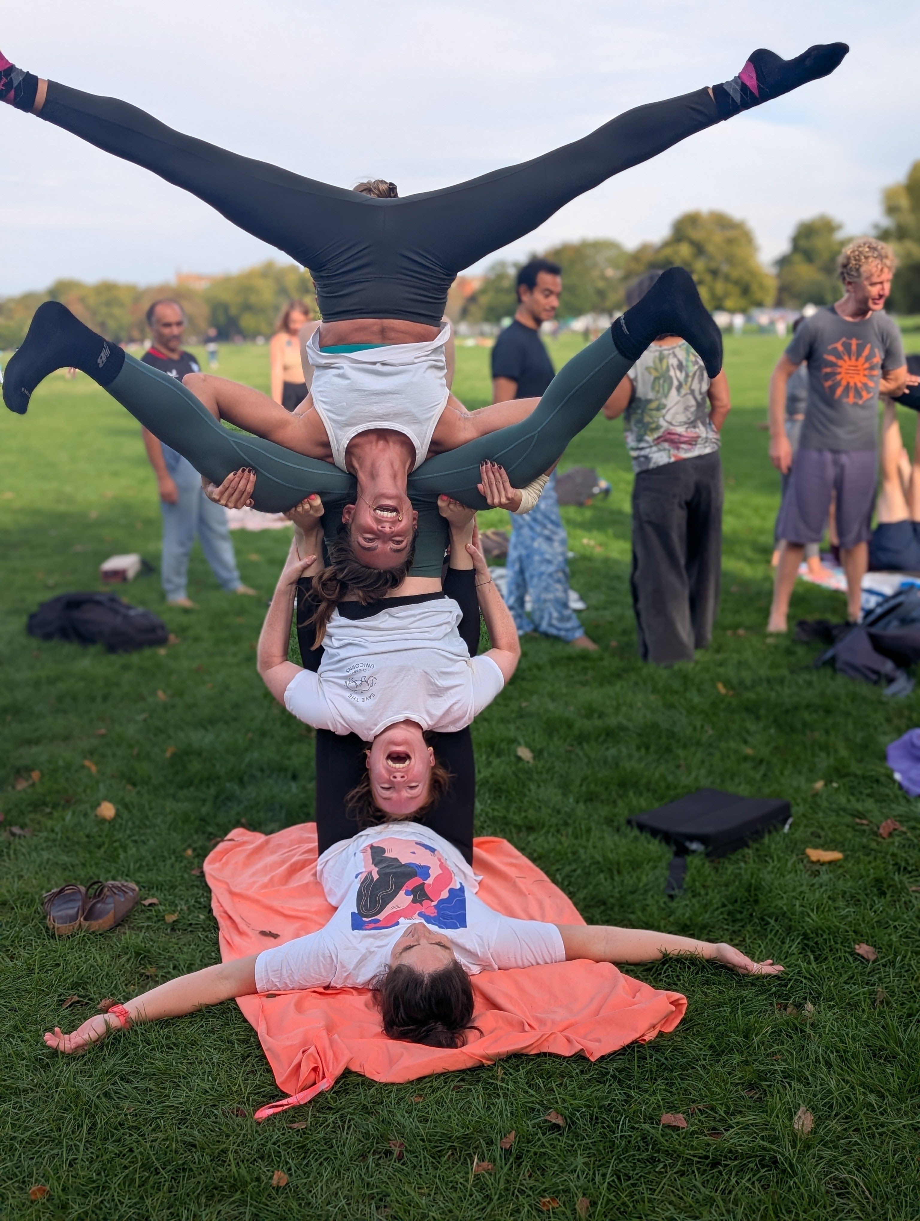 A trio acro inversion pose